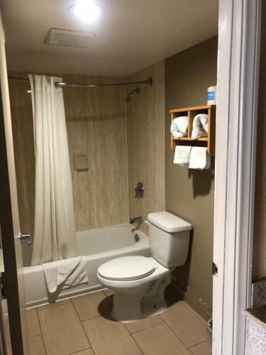 a bathroom with a toilet and a shower and a tub at Northgate Motel in El Cajon