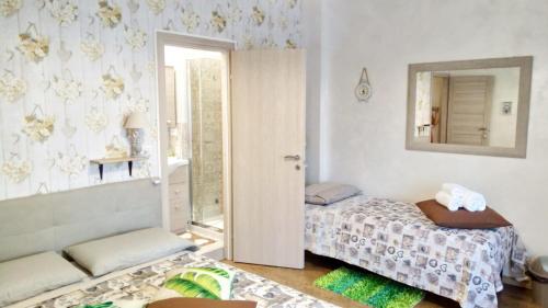 um pequeno quarto com uma cama e um espelho em San Pietro Shabby Chic Apartment em Roma