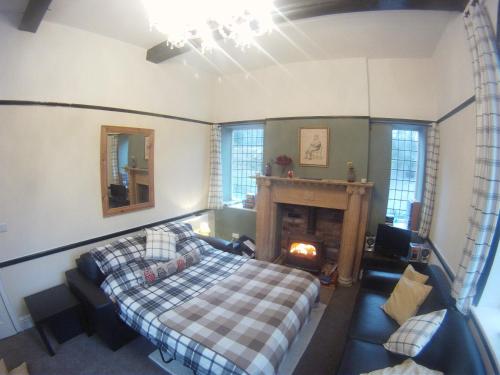 ein Schlafzimmer mit einem Bett und einem Kamin in der Unterkunft Gamekeepers Cottage in Hayfield