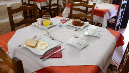 a table with a plate of breakfast food and a glass of orange juice at Hotel Rural Finca La Hacienda in Los Silos