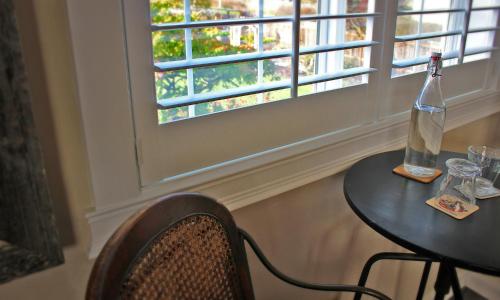 a table with a bottle on it next to a window at Dungeness Barn House Bed and Breakfast at Two Crows Farm in Sequim