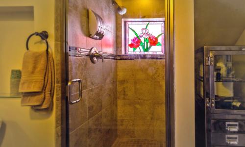 a bathroom with a shower with a glass door at Dungeness Barn House Bed and Breakfast at Two Crows Farm in Sequim