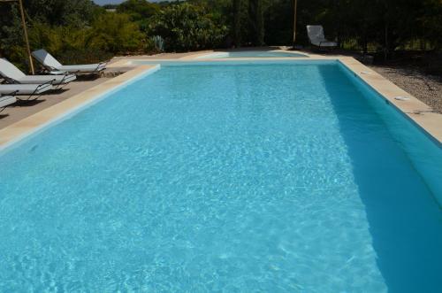 a large blue swimming pool with lounge chairs in it at Casa Naima in Ida Ougourd
