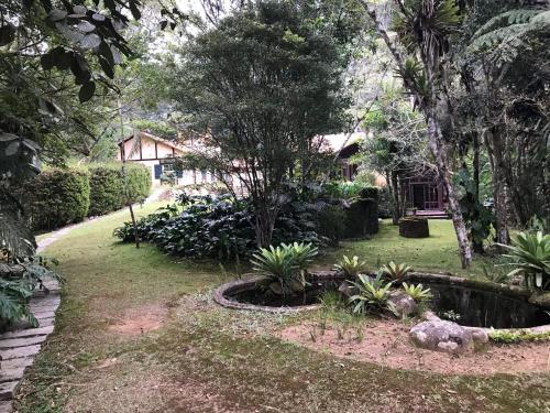 a garden with a pond in front of a house at Fachoalto Budget in Petrópolis