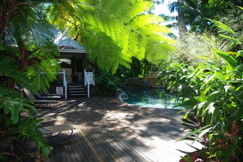 a patio with a view of the water and trees at Palm Cove Tropic Apartments in Palm Cove