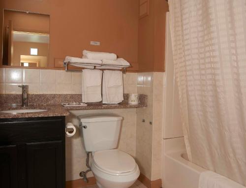 a bathroom with a toilet and a sink and a mirror at New World Inn in Barre