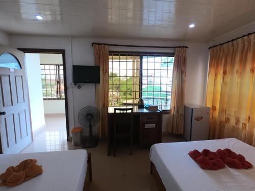 - une chambre avec 2 lits, un bureau et des fenêtres dans l'établissement The Bright Lotus Guesthouse, à Phnom Penh