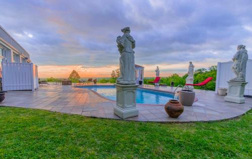 a swimming pool with statues next to a house at Weymouth Hall in Natchez