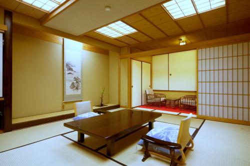 a room with a table and chairs in a room at Asanoya in Shinonsen