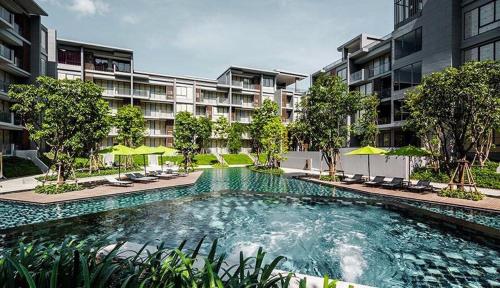 a swimming pool in front of a apartment building at The Valley Khaoyai Tropical Style in Ban Huai Sok Noi