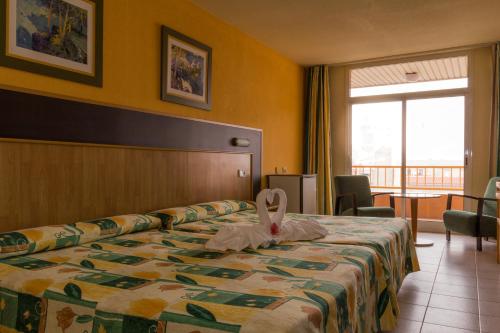 a hotel room with a bed with a towel on it at Hotel La Rápita in Sant Carles de la Ràpita