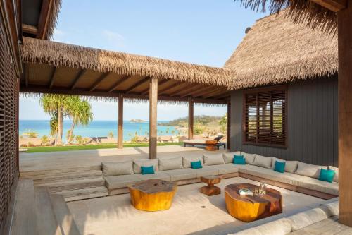 a living room with a couch and a view of the ocean at Six Senses Fiji in Malolo