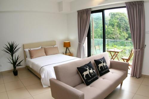 a bedroom with a bed and a couch and a window at RELAX & COZY HOME @ MIDHILLS GENTING in Genting Highlands