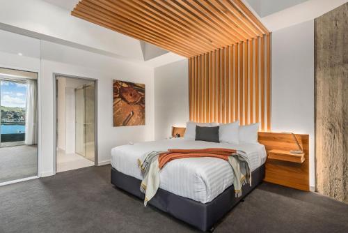 a bedroom with a large bed and a large window at Peppers Silo in Launceston