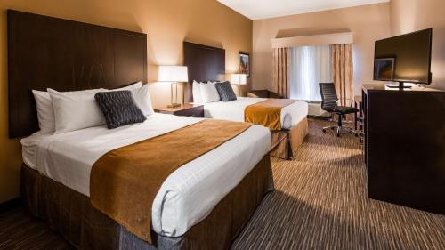 una camera d'albergo con due letti e una televisione di Best Western False River Hotel a New Roads