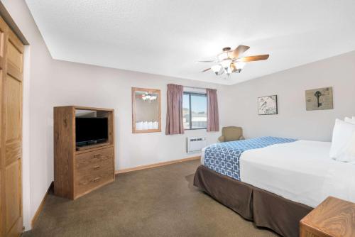 a bedroom with a bed and a flat screen tv at Days Inn by Wyndham Spearfish in Spearfish