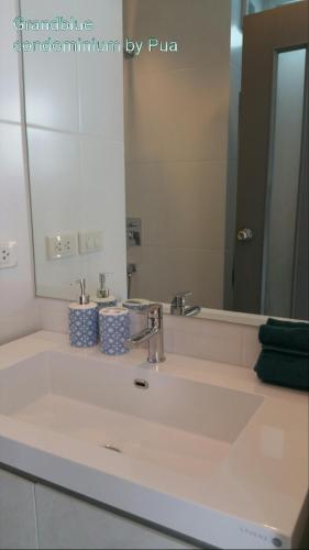 a bathroom sink with a large mirror and a sink at Grandblue condominium 106,302 in Mae Pim
