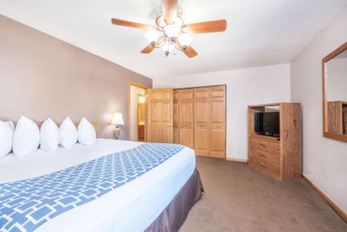 a bedroom with a bed and a ceiling fan at Days Inn by Wyndham Spearfish in Spearfish