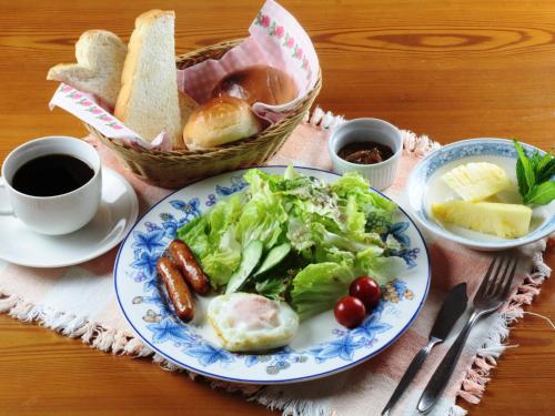 un piatto di cibo con insalata, pane e una tazza di caffè di Pension Peppermint House a Hara