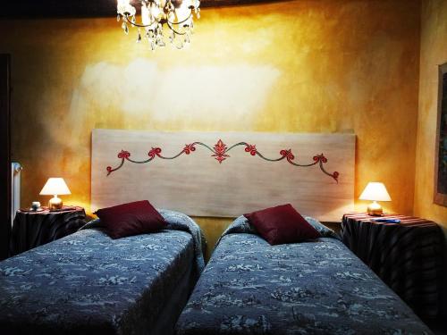 斯波莱托Sotto i tetti del borgo的一间卧室设有两张床和两张带台灯的桌子。