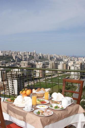 a table with plates of food on a balcony at Padova Hotel in Beirut