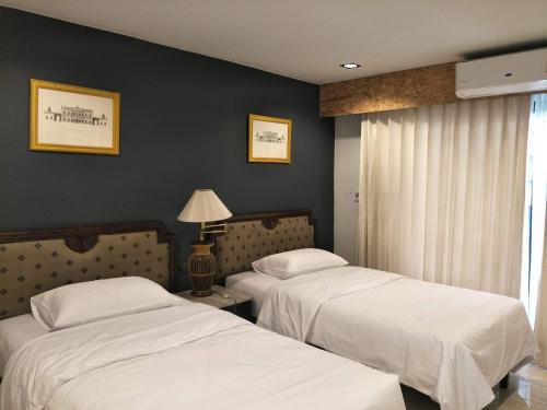 sypialnia z 2 łóżkami i oknem z lampką w obiekcie The 92 Residence w mieście Bangkok