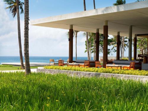 a pavilion with chairs and the ocean in the background at Dialoog Banyuwangi in Banyuwangi