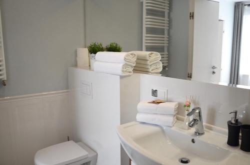 a bathroom with a sink and a toilet and a mirror at Apartamenty Turystyczne WillkasSen in Giżycko