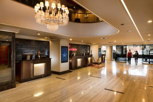 a lobby with a bar and a chandelier at Stamford Plaza Adelaide in Adelaide