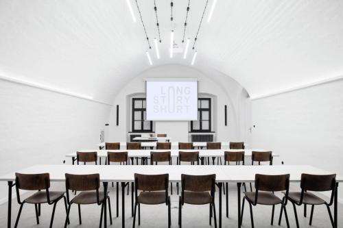 a large room with a large table and chairs at Long Story Short Hostel & Café in Olomouc