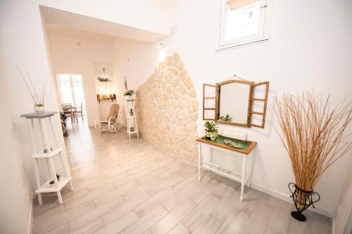 a hallway with a mirror on a wall and a table at Castrum Lodge in Palermo