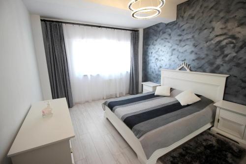 a bedroom with a bed and a large window at Apartament Diana in Târgu-Mureş