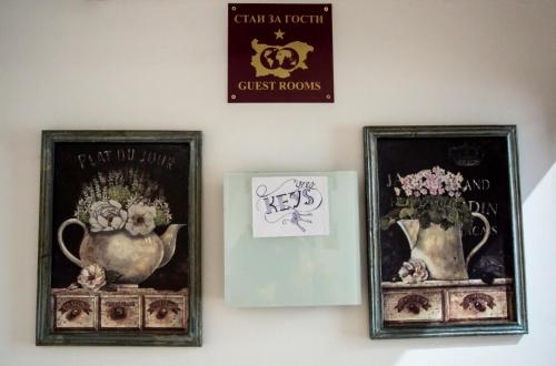 two framed pictures of vases and a sign on a wall at Serdika Rooms in Sofia