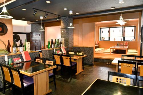 un restaurante con mesas, sillas y una barra en New Commander Hotel Osaka Neyagawa, en Neyagawa