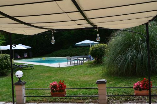 - une piscine avec un grand parasol beige dans l'établissement Manoir Le Bourg, Touffailles, à Touffailles