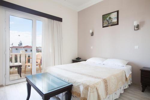 um quarto branco com uma cama e uma mesa de vidro em Exotic Hotel & SPA em Boghaz
