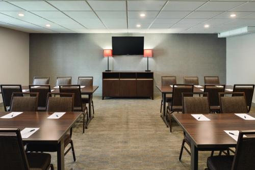 ラクロスにあるCountry Inn & Suites by Radisson, La Crosse, WIのテーブルと椅子とテレビのある会議室