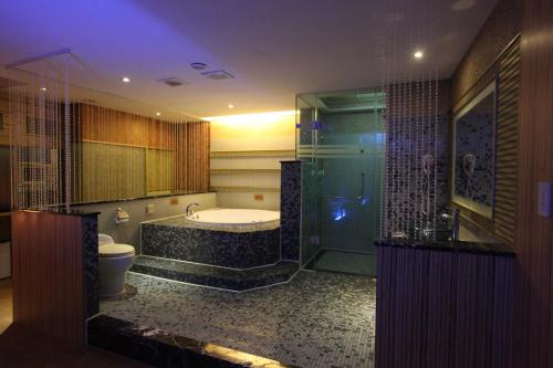 La salle de bains est pourvue d'une baignoire, de toilettes et d'une douche. dans l'établissement Venice Motel, à Kaohsiung