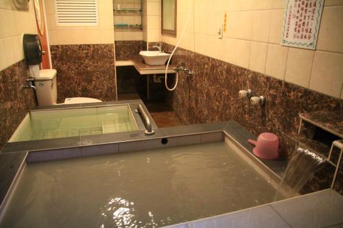 a bath tub filled with water in a bathroom at Li Tang in Baihe