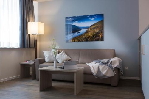 a living room with a couch and a table with a laptop at Cozy-Flats Koblenz in Koblenz