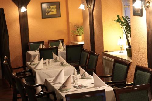a dining room with tables and chairs with white table cloth at Radduscher Hafen in Vetschau
