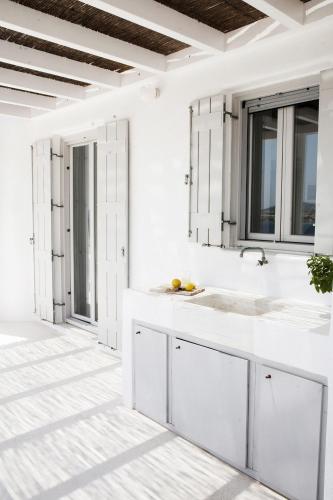a white kitchen with a sink and windows at Luxury Villa Seafront in Aliki
