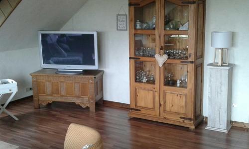 a living room with a television and a wooden cabinet at Komfort_Ferienwohnung in Geldern