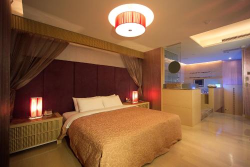 a bedroom with a large bed and a kitchen at Venice Motel in Kaohsiung