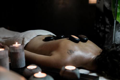a woman laying on a table with a towel and some candles at Logis LE RABELAIS Hôtel- Restaurant - SPA in Fontenay-le-Comte