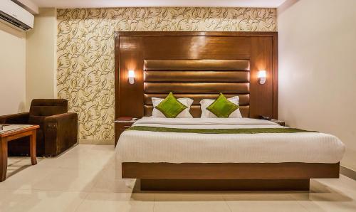 a bedroom with a large bed with a wooden headboard at Treebo Grand Legacy Elite With Roof Top Cafe in Dehradun