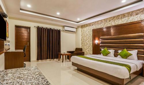 a hotel room with a bed and a desk at Treebo Grand Legacy Elite With Roof Top Cafe in Dehradun