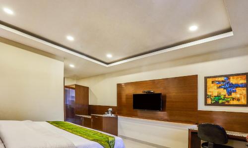a bedroom with a bed and a flat screen tv at Treebo Grand Legacy Elite With Roof Top Cafe in Dehradun