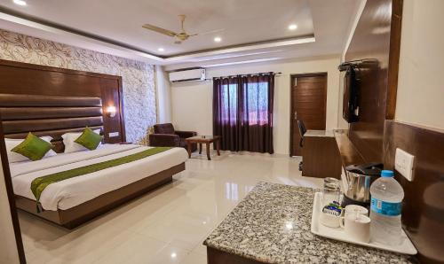 a hotel room with a bed and a desk at Treebo Grand Legacy Elite With Roof Top Cafe in Dehradun