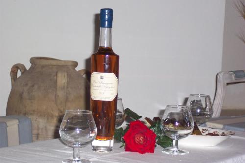 a bottle of wine sitting on a table with three wine glasses at Masseria Ruri Pulcra in Patù